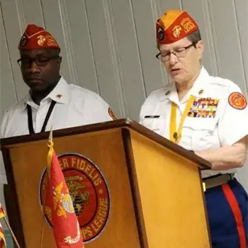 Ellen Leidy giving a speech at a podium in her uniform.